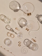 Golden jewelry with lots of cocktail glasses, on the beige background