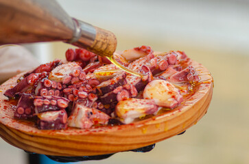 Olive oil on a portion of octopus, prepared in the traditional recipe Pulpo a feira style. Galicia,...