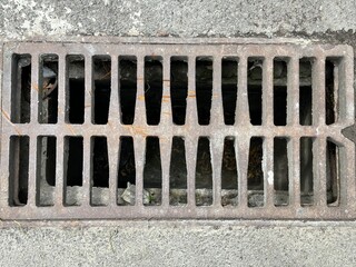 Rusty sewer drain grate closeup. Metal sewer grate on asphalt road