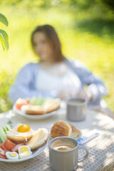 breakfast in the garden in summer food on the table, eggs buns and coffee