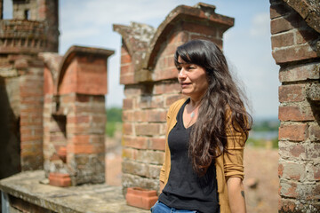 Contemplative woman by historical brickwork