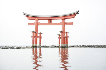 Naklejka premium Traditional Japanese Torii Gate Reflecting in Calm Water