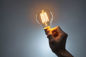 Hand Holding Lit Light Bulb