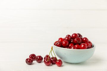 Cherries. Fresh ripe cherries with leaves on a textured wooden background. Fresh sweet organic cherry pile. Berries and fruits. Vegan. Healthy eating. Place for text. Copy space