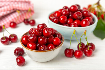 Cherries. Fresh ripe cherries with leaves on a textured wooden background. Fresh sweet organic cherry pile. Berries and fruits. Vegan. Healthy eating. Place for text. Copy space