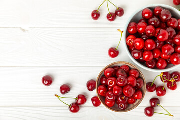 Cherries. Fresh ripe cherries with leaves on a textured wooden background. Fresh sweet organic cherry pile. Berries and fruits. Vegan. Healthy eating. Place for text. Copy space