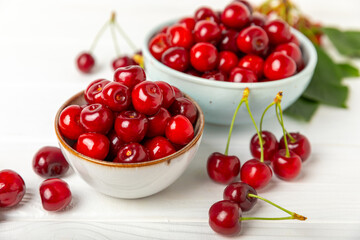 Cherries. Fresh ripe cherries with leaves on a textured wooden background. Fresh sweet organic cherry pile. Berries and fruits. Vegan. Healthy eating. Place for text. Copy space