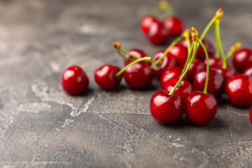 Cherries. Fresh ripe cherries with leaves on a textured wooden background. Fresh sweet organic...