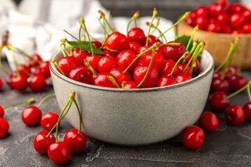 Cherries. Fresh ripe cherries with leaves on a textured wooden background. Fresh sweet organic...