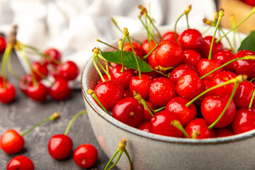 Cherries. Fresh ripe cherries with leaves on a textured wooden background. Fresh sweet organic cherry pile. Berries and fruits. Vegan. Healthy eating. Place for text. Copy space