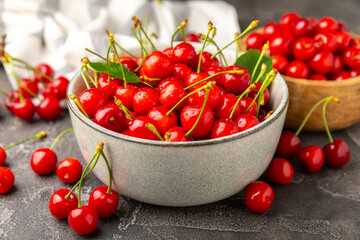 Cherries. Fresh ripe cherries with leaves on a textured wooden background. Fresh sweet organic cherry pile. Berries and fruits. Vegan. Healthy eating. Place for text. Copy space
