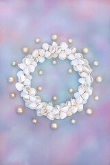 Oyster pearl and cockleshell sea shell wreath on rainbow sky cloud background. Symbol of summer...
