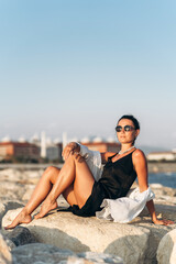 Woman sitting on rock by water