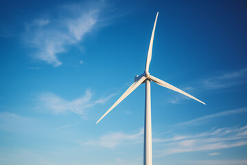 Fototapeta premium Single wind mill turbine in front of blue sky