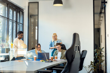 Diverse group of young people working on new project together in office.