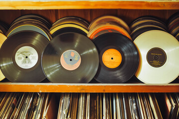 A collection of vintage vinyl records arranged on a shelf, capturing the nostalgia and retro vibe...