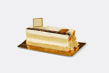 Slice of fluffy biscuit cake with delicate cream and almond
