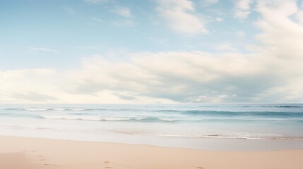 Fototapeta premium A serene beach scene with gentle waves, a blue sky filled with clouds, and footprints in the sand.