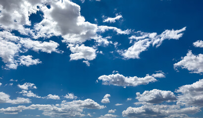 Fluffy cumulus clouds on blue sky background. Cloudscape