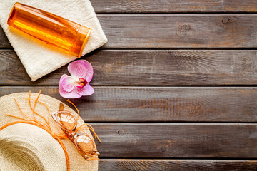 Summer holiday beach background. Female straw hat with sunscreen and sunglasses, top view