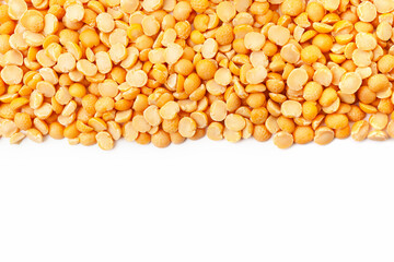 Uncooked, yellow peas border on white background. Copy space for text. Top view