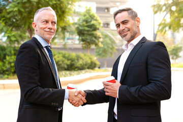 Two colleagues face each other, high-five, look at the camera, work as a team, ready to start a new...