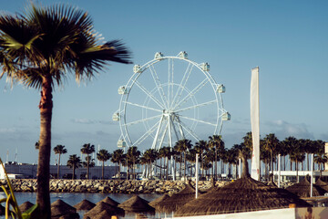 Ferris wheels on the street. Seascape at the marina