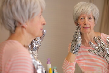 Senior woman hydrating her hands with a super tonic 