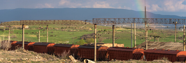 Old train cars, rainbow in the sky