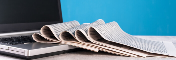 Newspapers on laptop, information, media concept, old and new sources of information
