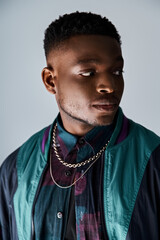Handsome African American man wearing a stylish jacket and necklace.