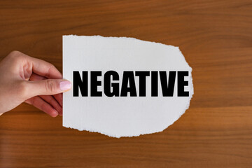 Negative. Woman hand holds a piece of paper with a note, negative. Decline, opposite, contrary,...