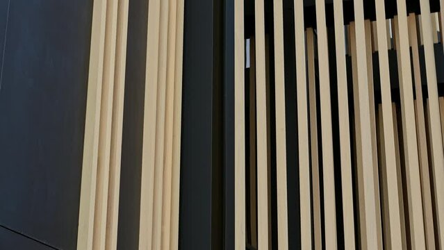 Close-up of a contemporary building facade with vertical wooden slats and dark paneling for a stylish look.