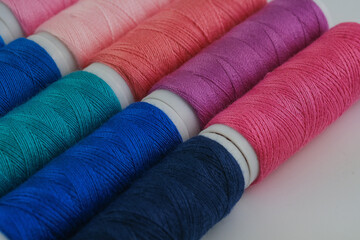 Numerous spools of thread neatly arranged in a row next to each other