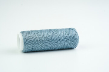 A spool of thread neatly placed on a clean white surface