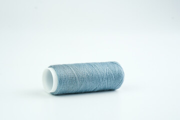 A single spool of thread placed on a clean white background