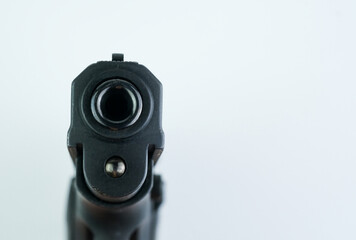 Detailed view of a black gun against a stark white background, showcasing its design and features