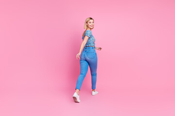 Full body rear portrait of nice young lady walk empty space wear top isolated on pink color background