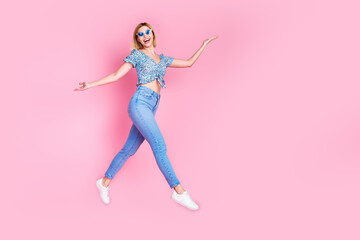 Full length photo of charming girly woman wear blue blouse dark eyeglasses jumping high empty space isolated pink color background