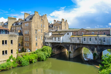 Fototapeta premium UK, Bath, 26.05.2024: Pulteney weir and a view of the Pulteney bridge, an ohn of 4 bridges in Europe with buildings on it
