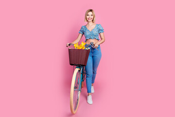 Full body portrait of nice young lady walk bicycle wear top isolated on pink color background