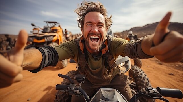 Thrilling selfie of an exuberant man on an all-terrain vehicle in the desert