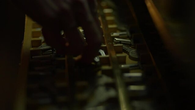 A collection of assorted keys in a box, with intricate shadows caught in a macro shot