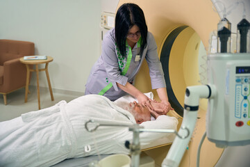 Lady doctor placing patient in MRI machine