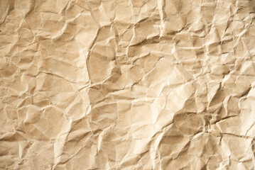 Creased, wrinkled crumpled brown cardboard. Recyclable material, texture, vintage paper