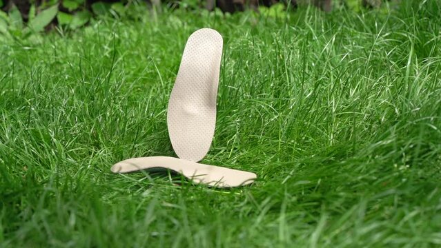 Orthopedic insoles for shoes on a background of green grass