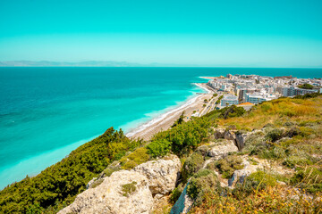 Aegean beach with sunshades in city of Rhodes (Rhodes, Greece)