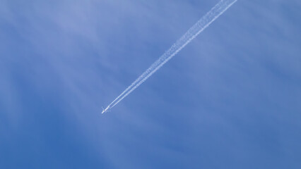 a jet plane flies through the blue sky on a sunny day