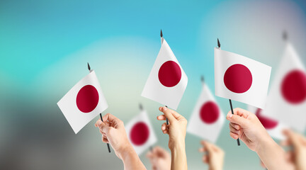 A group of people are holding small flags of Japan in their hands.