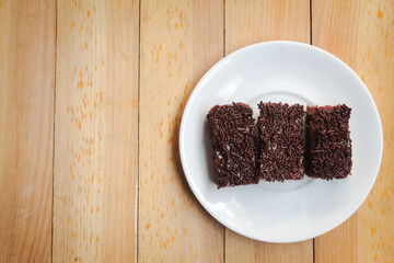 Homemade chocolate brownies on a plate, with negative space